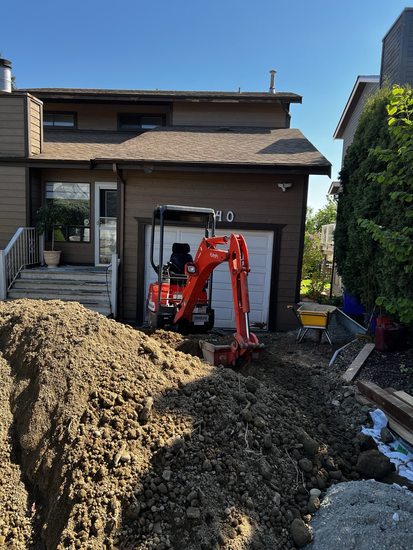 An excavator moving soil on a residential lot