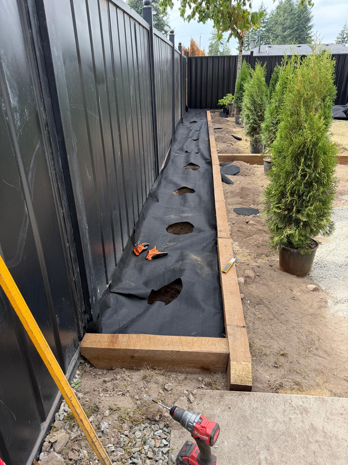 Landscape fabric and posts set before a fence goes up